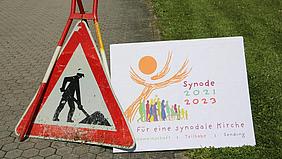 Baustellenschild mit Plakat der Synode